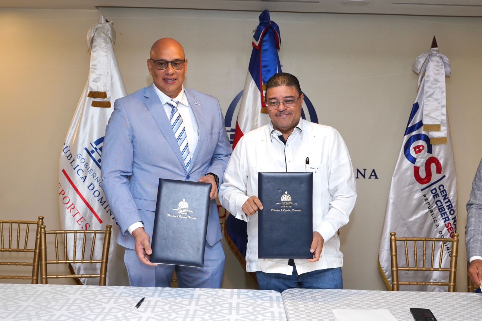 Juan Gabriel Gautreaux Martínez, director ejecutivo del CNCS, y el ministro de Deportes, Francisco Camacho Rivas, presentan el convenio interinstitucional tras ejecutar sus respectivas firmas.