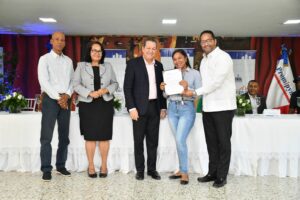Autoridades del Gobierno hacen entrega del préstamo a una de las beneficiarias.