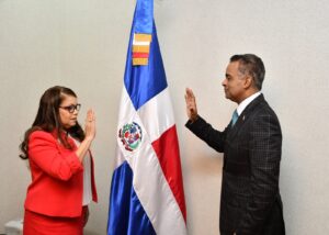 Momento en que el ministro Joel Santos Echavarría toma el juramento a Digna Reynoso como directora de Pasaportes.