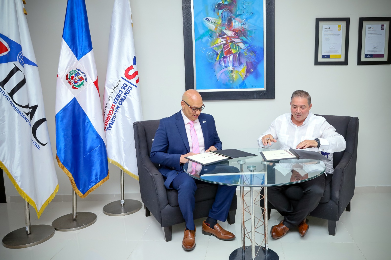 Héctor Porcella, director general interino del IDAC y el coronel Juan Gabriel Gautreaux, director ejecutivo del CNCS, firmando el acuerdo